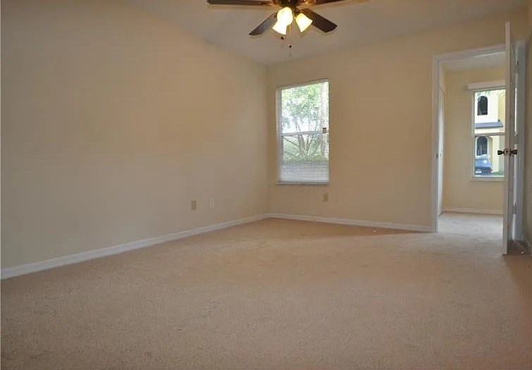 A room with a ceiling fan and a window.
