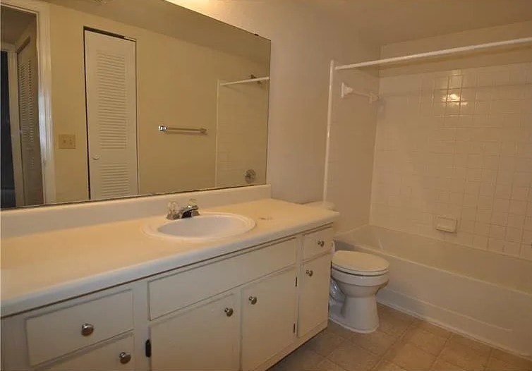 A white bathroom with a sink, toilet, and bathtub.