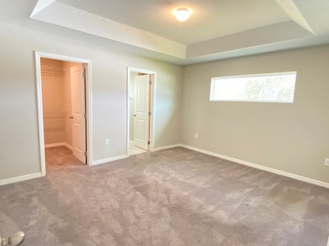 an empty living room with a door to a closet and a window