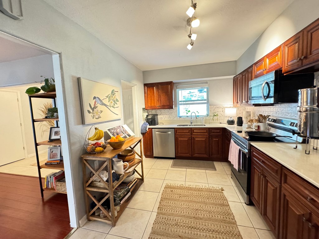 a kitchen with wooden cabinets and a sink and a refrigerator