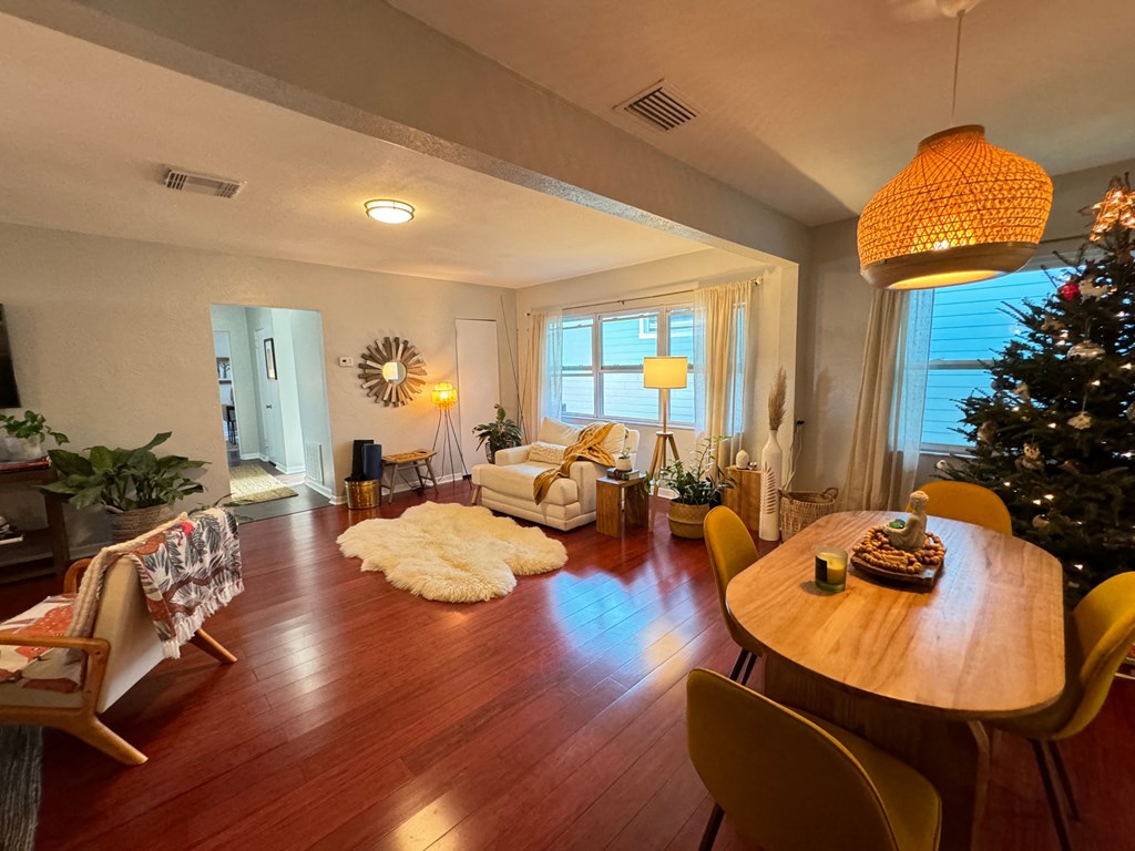 a living room and dining room with a christmas tree