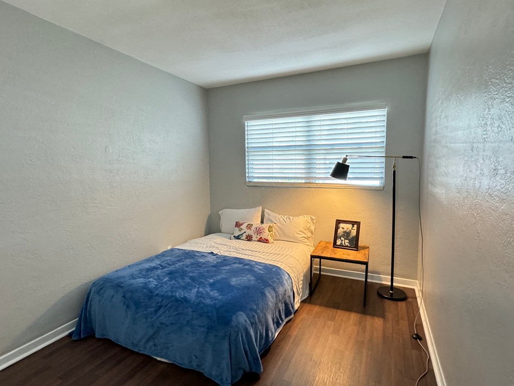 a small bedroom with a bed and a window