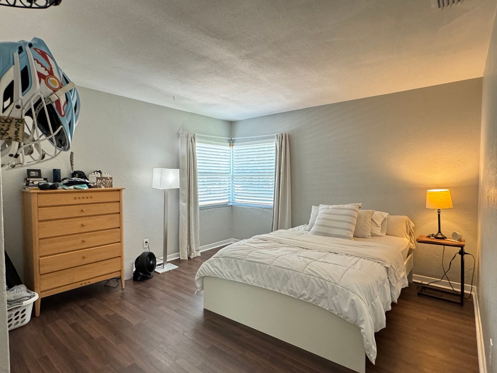 a bedroom with a bed and a dresser and a window