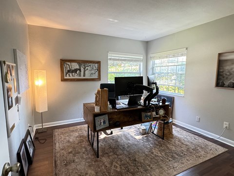 the living room of a home with a desk and a tv