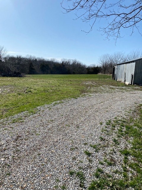 A gravel path leads to a small building in a field.