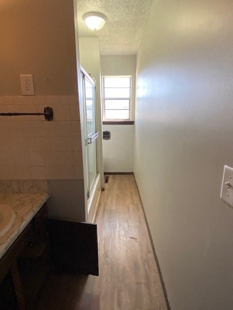 A bathroom with a marble counter top and wooden floors.