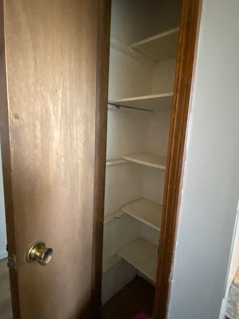 A brown door with a handle and a white wall behind it.