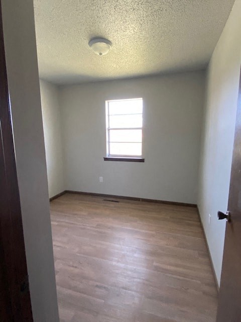 A room with a window and wooden floors.