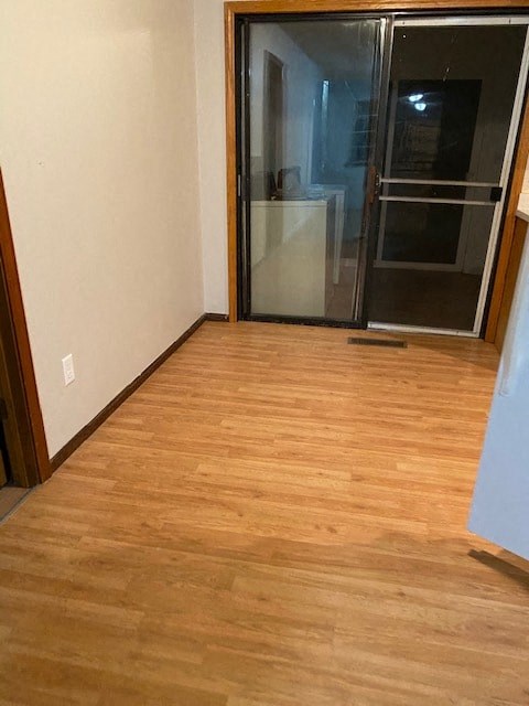 A room with wooden flooring and a sliding glass door.