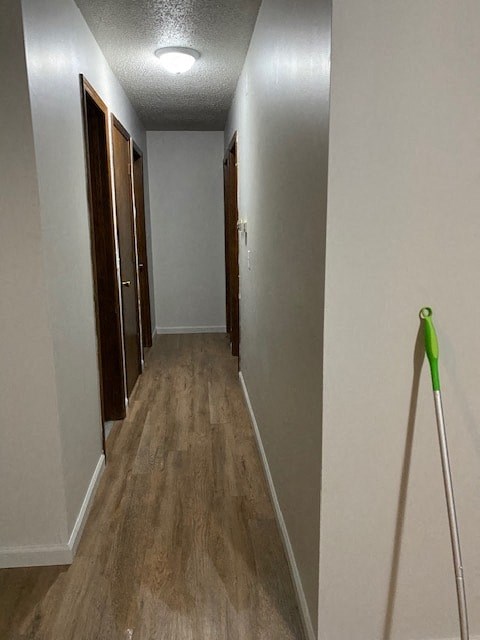 A long hallway with a broom on the right.