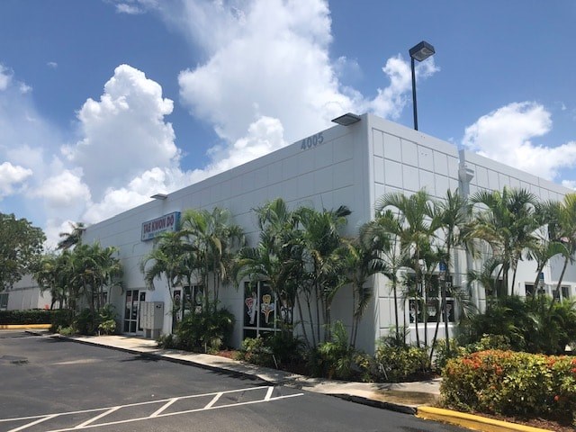 a white building with palm trees in front of it