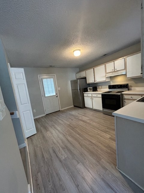 A kitchen with a stove top oven and a refrigerator.