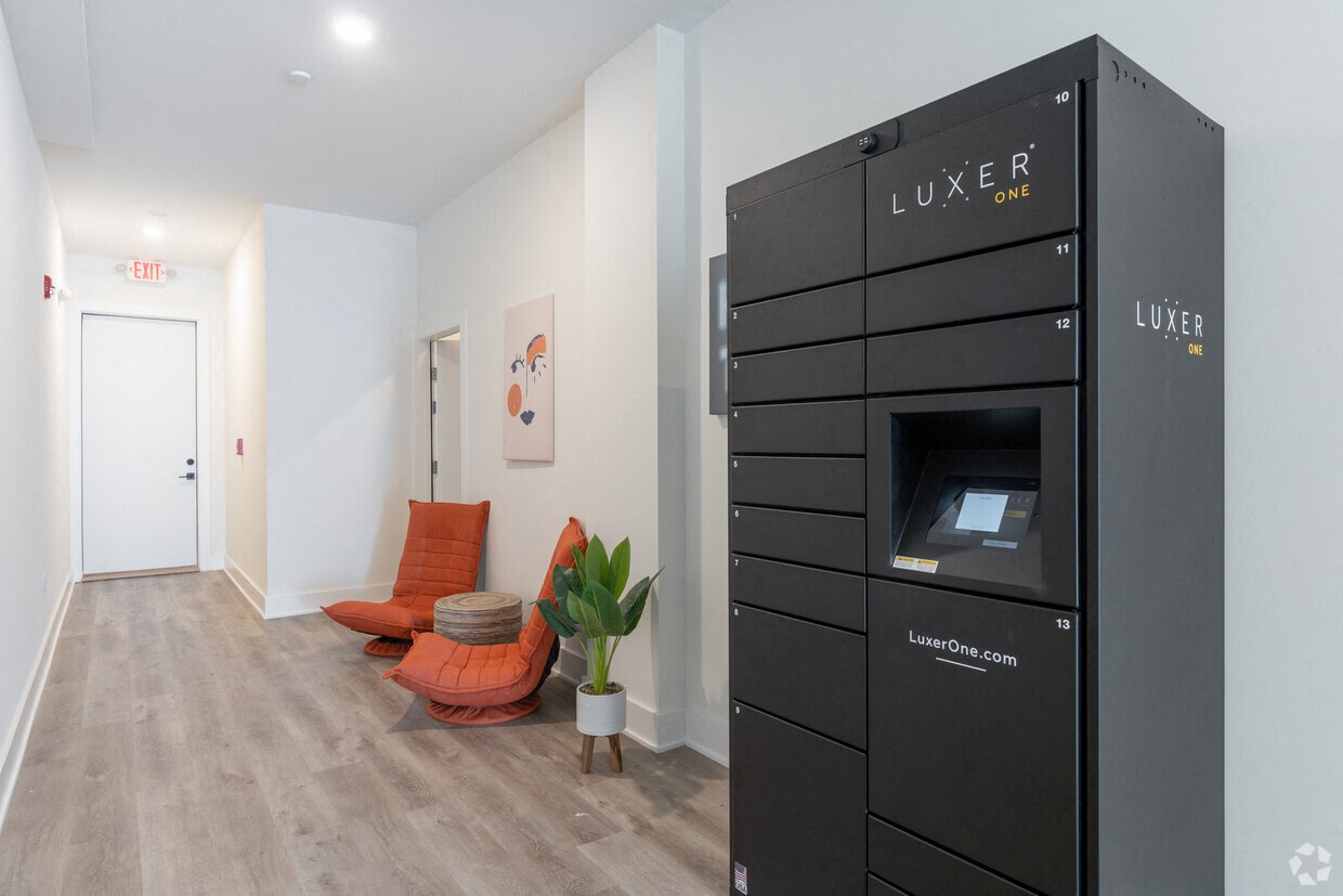 a small living room with a large black refrigerator and a couch