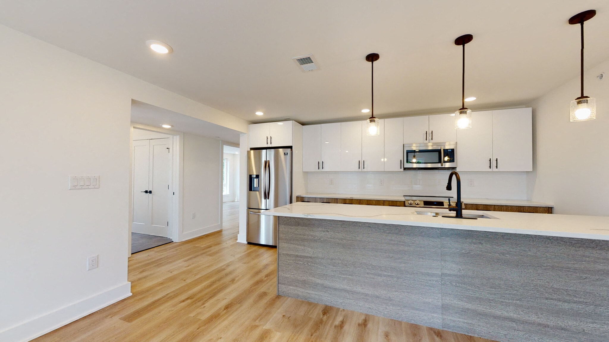 a kitchen with a large island and a stainless steel refrigerator