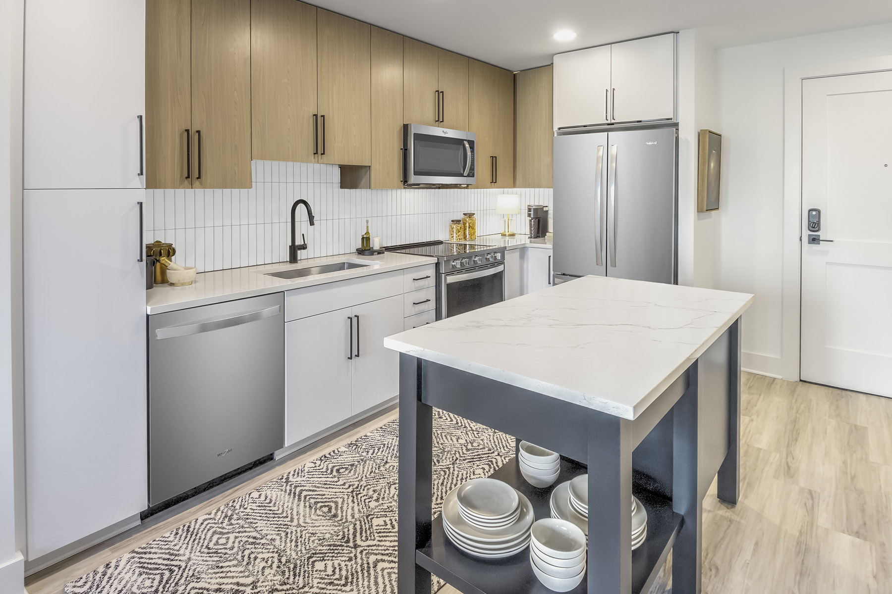 A kitchen with a white table and a refrigerator.