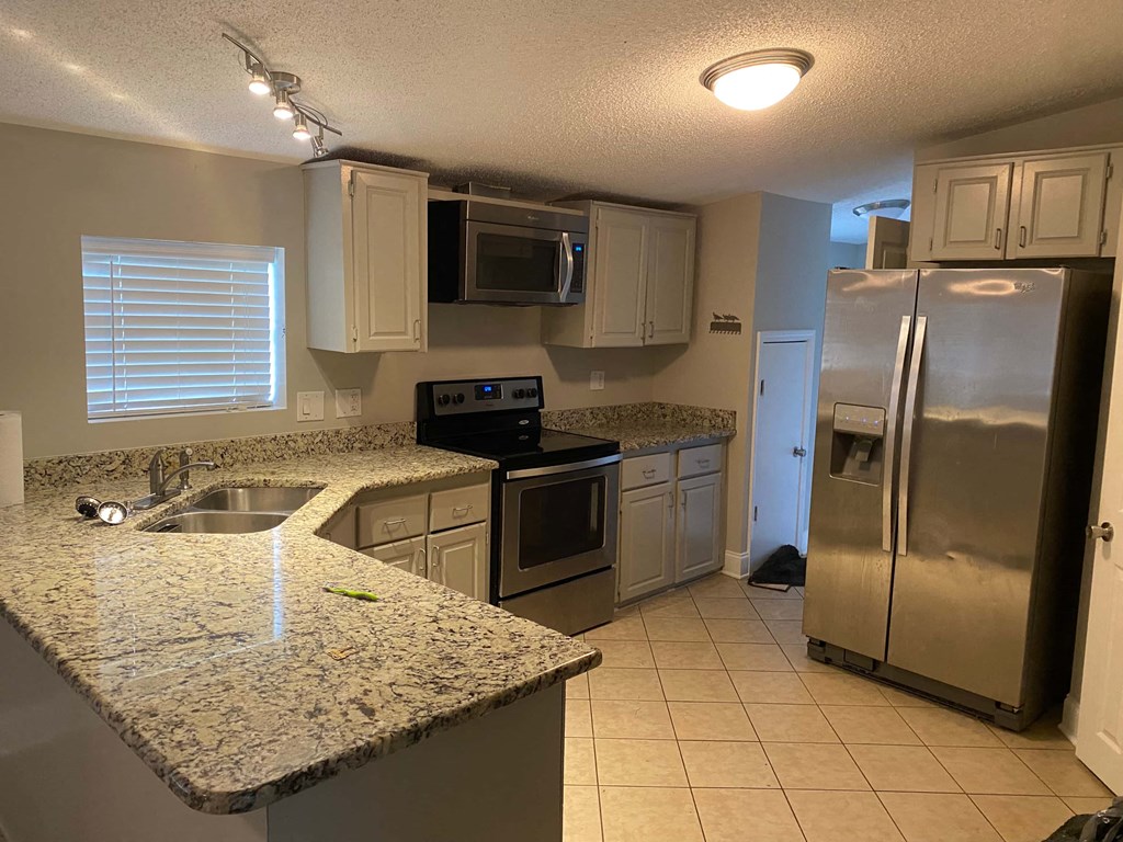 a kitchen with stainless steel appliances and granite counter tops