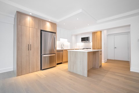 a kitchen with wooden cabinets and a stainless steel refrigerator