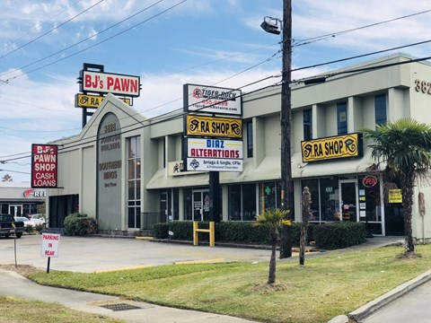 the front of a shopping center with signs for various businesses