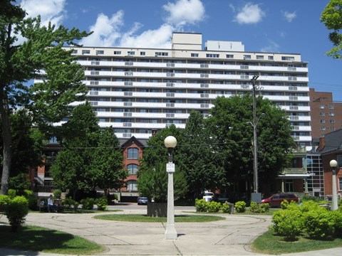 A tall white building with a red brick building in the background.
