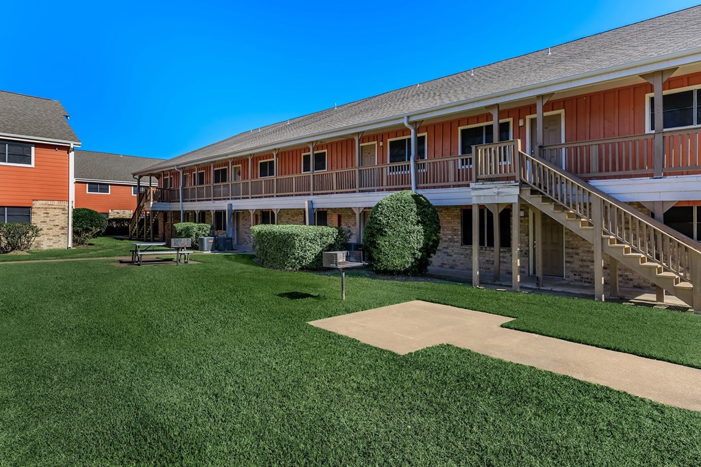 a yard in front of a building with a staircase