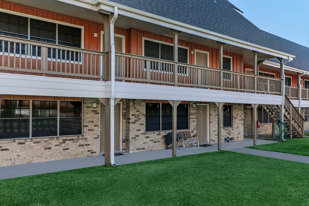 the front of a house with a porch and a balcony