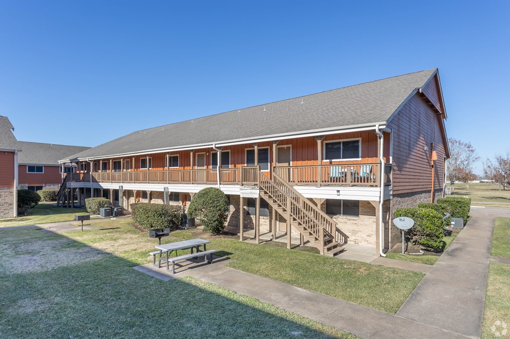 a building with a porch and a picnic table in front of it