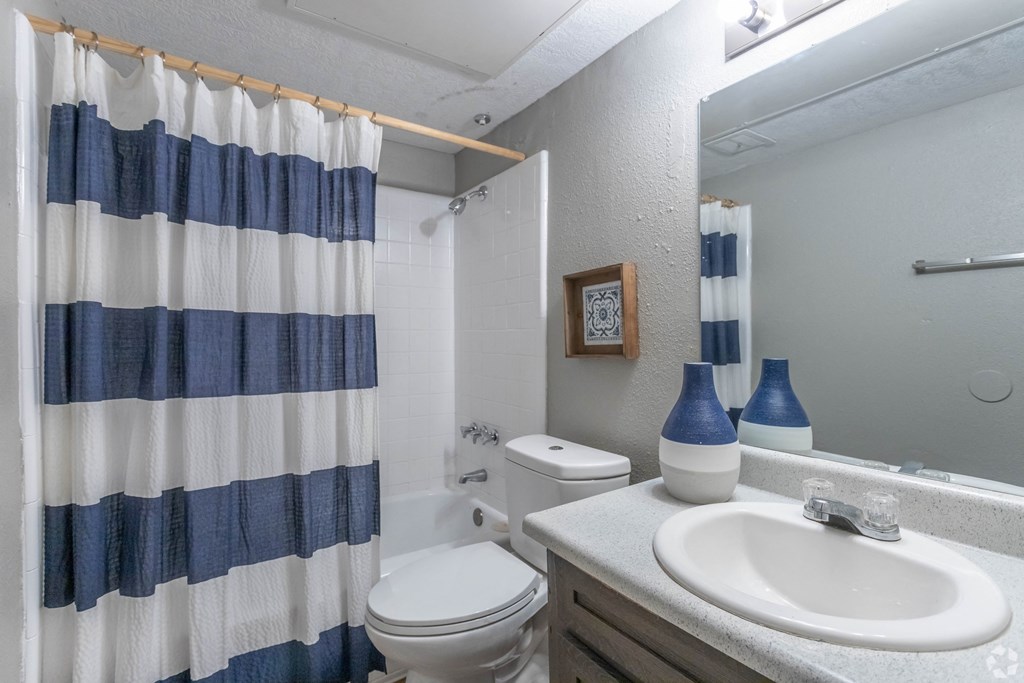 an updated bathroom with a blue and white shower curtain
