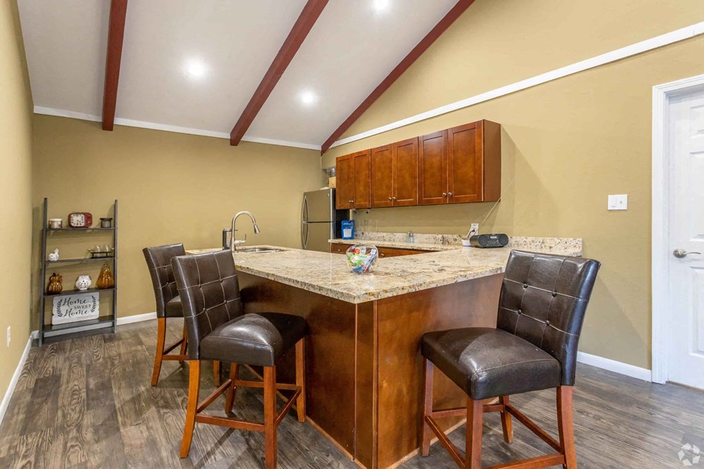 a kitchen with a counter top and chairs