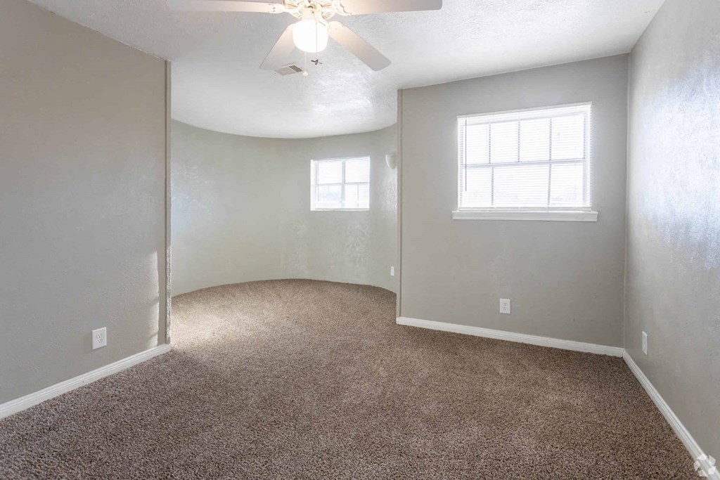 an empty room with carpet and a window