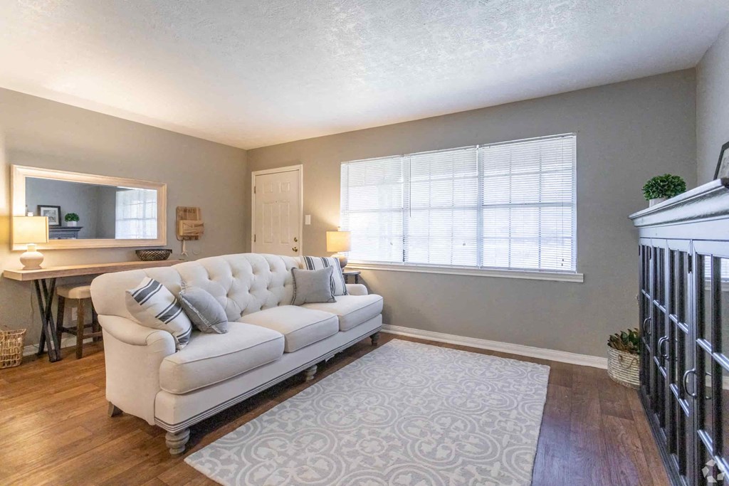 an empty living room with a couch and a rug