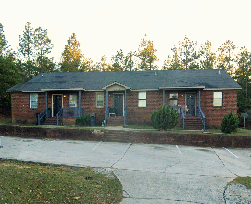 this is a picture of a brick house with a porch