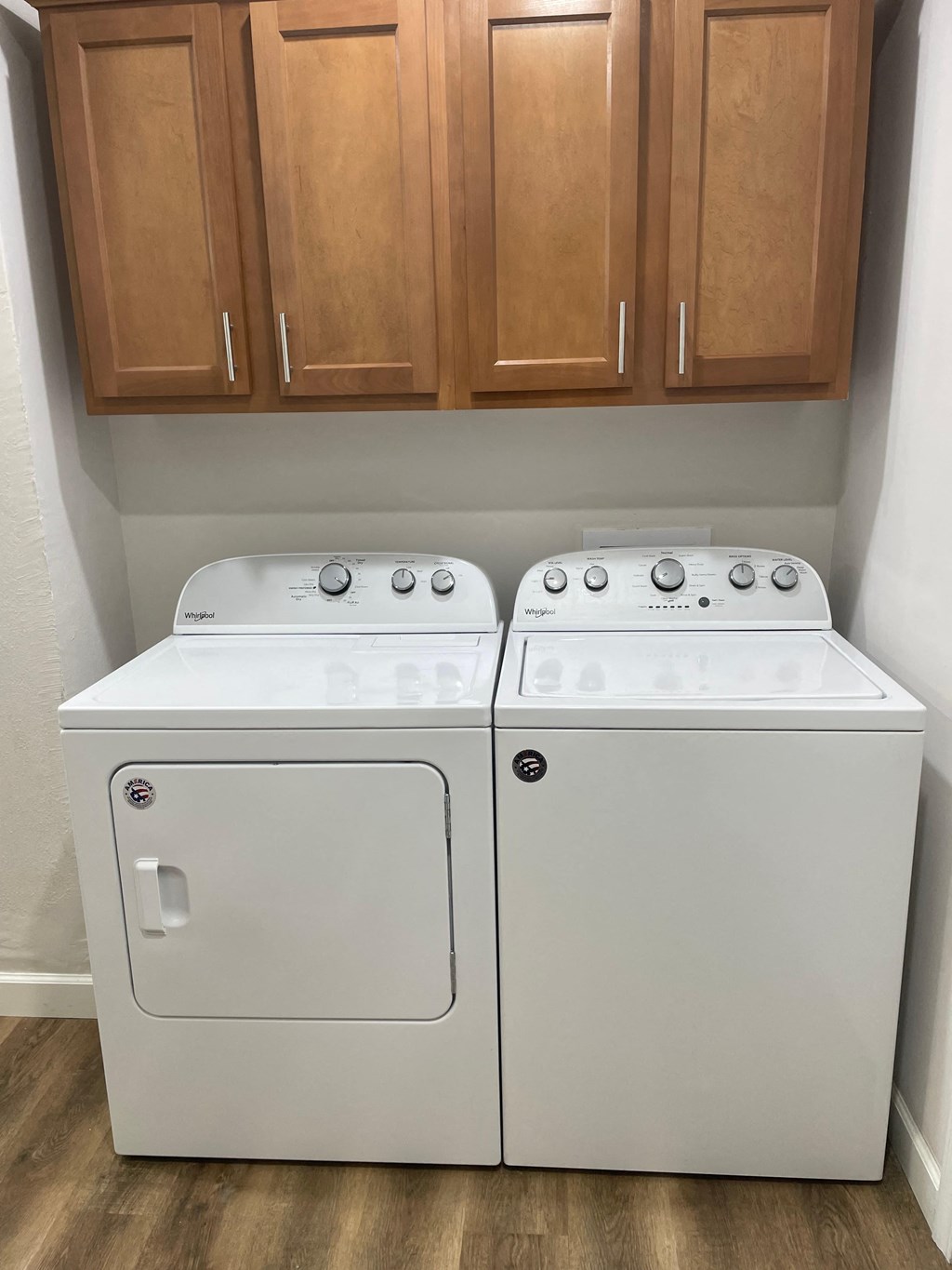 a washer and dryer in a room with wooden cabinets