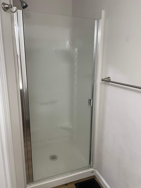 A glass shower door in a bathroom.