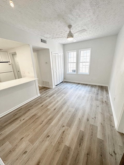 an empty living room with wood flooring in an empty house