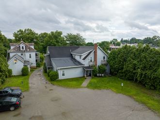 an aerial view of a house with a gray roof and a parking lot