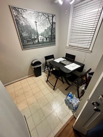 a dining room with a table and chairs and a picture on the wall
