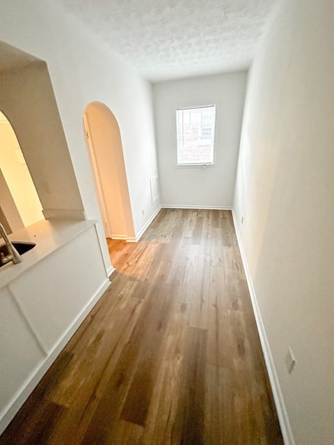 a renovated living room with hardwood floors and white walls