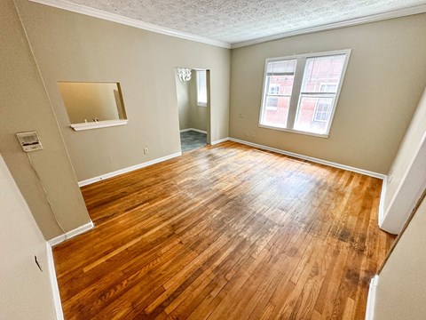 a living room with a hard wood floor and a window