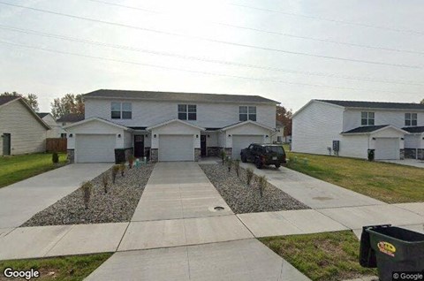 a white house with a car parked in the driveway