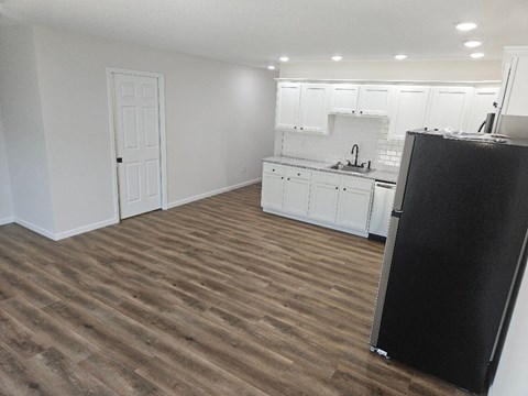a kitchen with white cabinets and a black refrigerator
