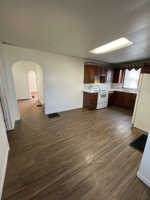 A kitchen with wooden floors and white walls.