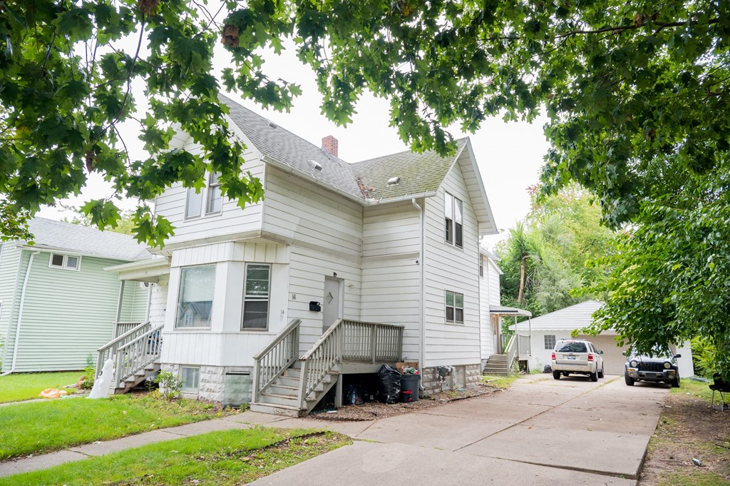a white house with a car parked in front of it