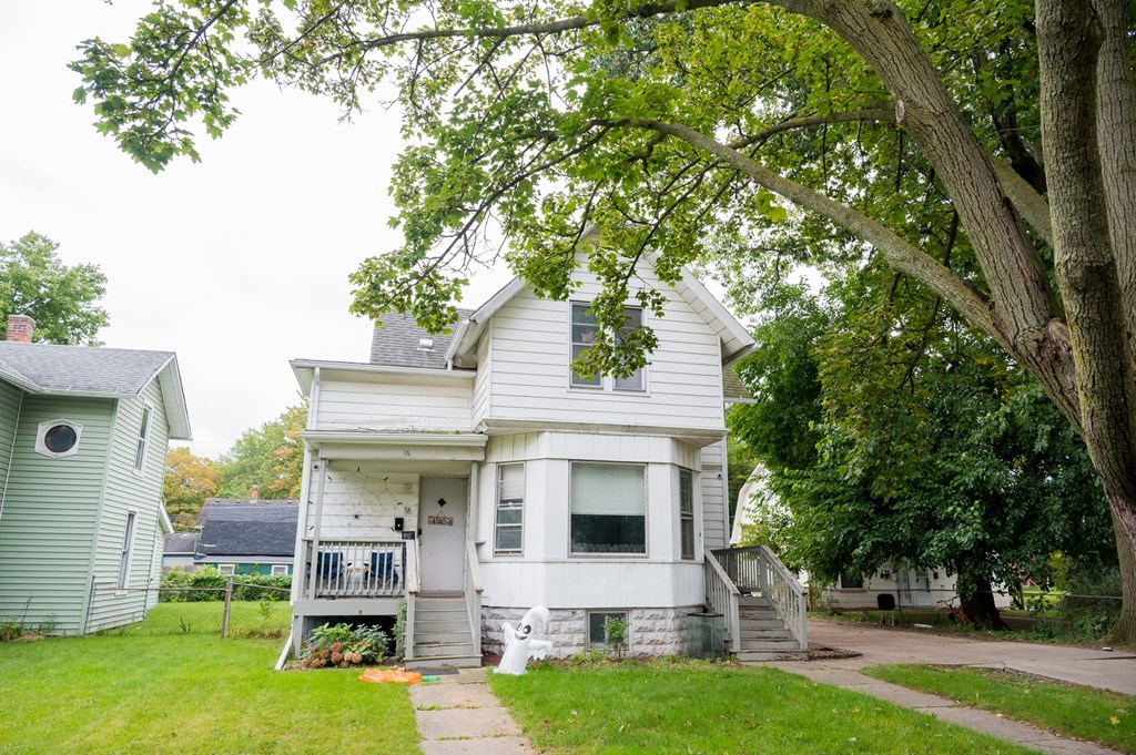 a white house with a tree in front of it