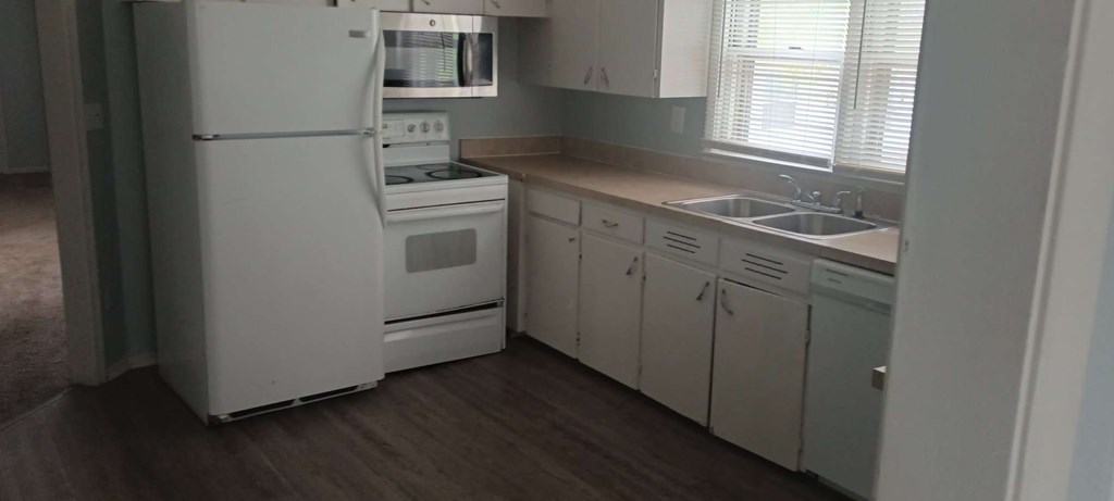 a kitchen with white appliances and white cabinets