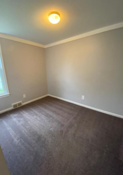 a empty room with wooden floors and a ceiling light