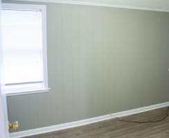 a room with green walls and a window and a wooden floor