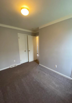 an empty living room with white walls and a carpet