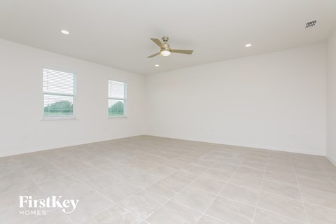 a living room with white walls and a ceiling fan