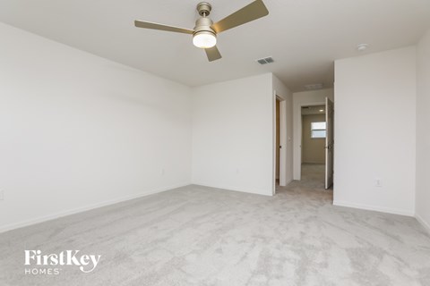 a clean and empty living room with a ceiling fan