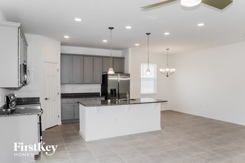 a white kitchen with a large island and stainless steel appliances